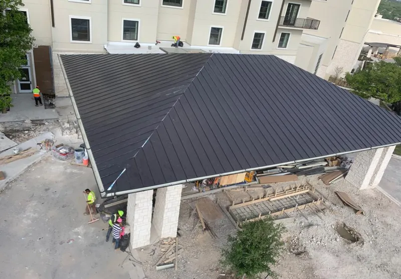 Metal roofing installation team working on a commercial building in Dover